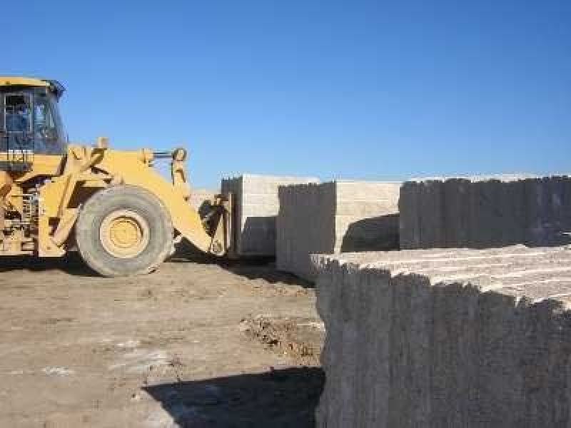 Maquinaria de obra transportando bloques de granito